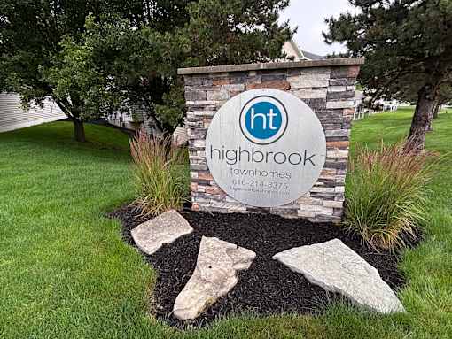 A sign for Highbrook townhomes with a website and phone number.