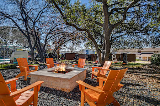 a group of orange chairs around a fire pit at Peaks at Northwest Hills Apartments, Texas, 78731