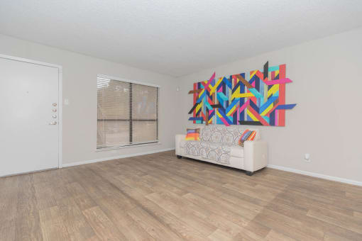 a living room with a couch and a painting on the wall at The Escapade, San Antonio, TX