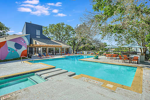 a swimming pool with a house in the background at Peaks at Northwest Hills Apartments, Austin, TX