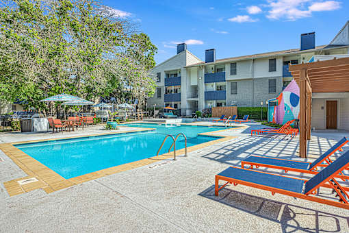 our apartments have a resort style pool with lounge chairs at Peaks at Northwest Hills Apartments, Austin, 78731