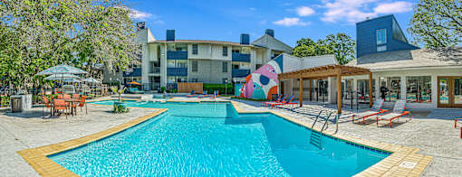 our apartments have a large swimming pool with chairs and umbrellas at Peaks at Northwest Hills Apartments, Austin, TX 78731