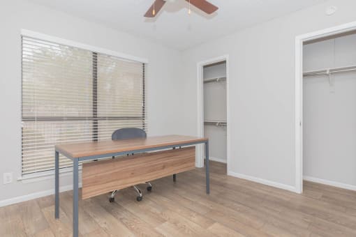 a room with a desk and a large window and a door to a closet at The Escapade, Texas