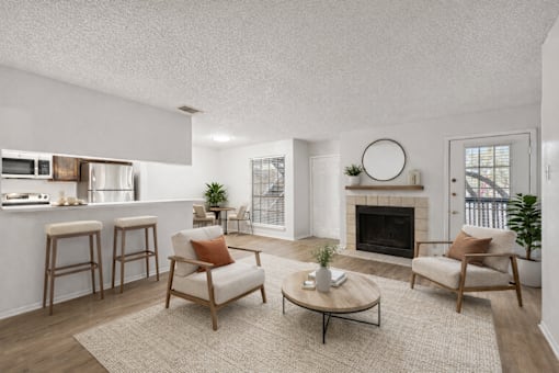 A living room with a fireplace, two chairs, and a coffee table.