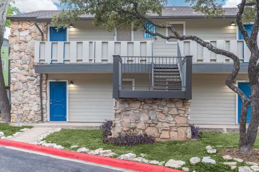a stone building with a balcony and a blue door at The Escapade, San Antonio, TX