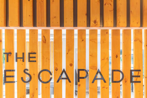 a sign for the escape room is painted on a wooden gate at The Escapade, San Antonio, 78216