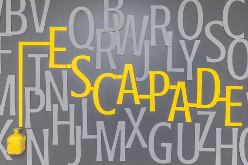 a wall filled with letters and a yellow vase at The Escapade, San Antonio, 78216