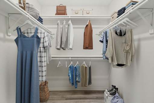 a walk in closet with a rack of clothes and a blue dress at The Escapade, San Antonio