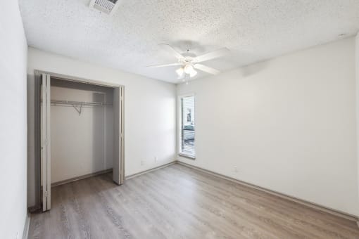 an empty room with a closet and a ceiling fan