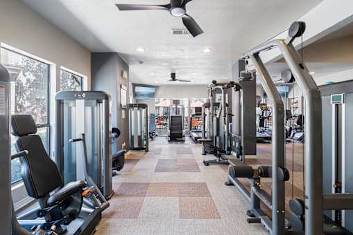 A gym with treadmills, weights, and exercise equipment.