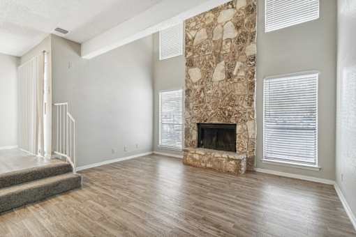 the living room has a large stone fireplace and hardwood floors at The Escapade, San Antonio