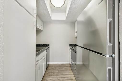 a kitchen with white cabinets and stainless steel appliances at The Escapade, San Antonio, 78216
