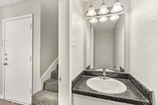 a bathroom with a sink and a mirror and a staircase at The Escapade, San Antonio, 78216