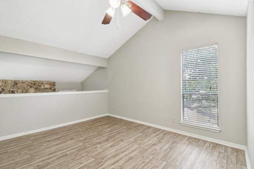 a bedroom with a large window and wood flooring at The Escapade, San Antonio