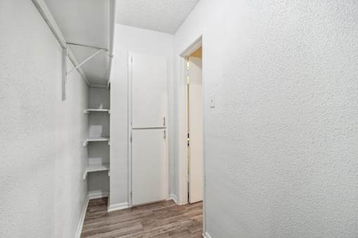 a walk-in closet with white walls and hardwood floors at The Escapade, San Antonio, Texas