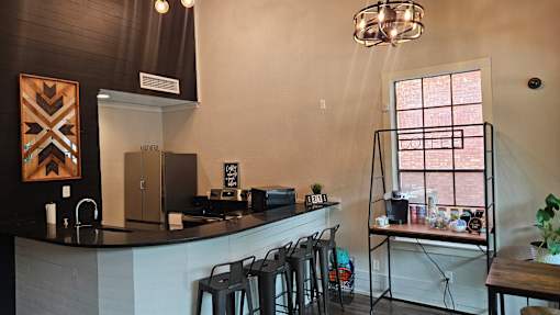 A kitchen with a black counter top and a white wall.