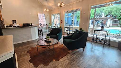 A living room with a black chair and a brown rug.