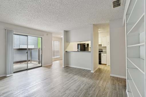 an open living room and kitchen with a sliding glass door at The Escapade, San Antonio, TX