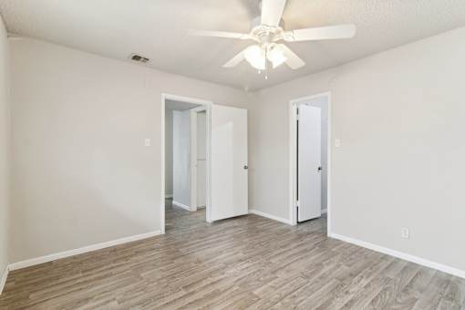 a spacious bedroom with white walls and a ceiling fan at The Escapade, San Antonio, Texas
