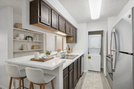 A kitchen with white countertops and a white refrigerator.