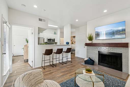 A modern living room with a fireplace and a bar area.
