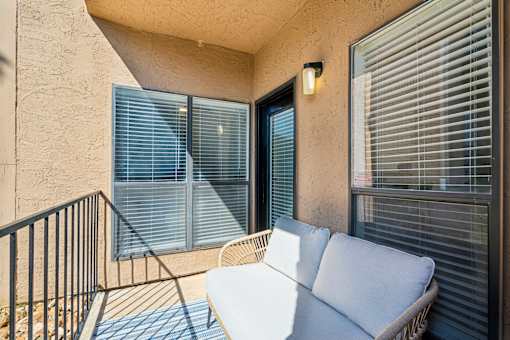 A balcony with a white sofa and a black railing.