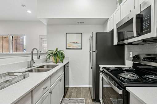 A modern kitchen with a black refrigerator and stove.