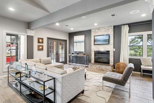 A modern living room with a fireplace and a grey couch.