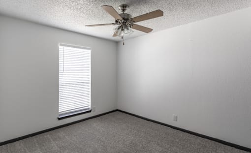 a bedroom with a ceiling fan and a window with a blind at Tradewinds, Windcrest, Texas