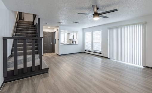 a living room with a staircase in the background and a couch in the foreground at Tradewinds, Windcrest, TX