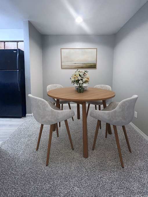 A dining room with a round table and chairs.