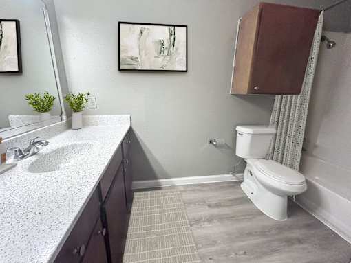 A bathroom with a white sink and a white toilet.