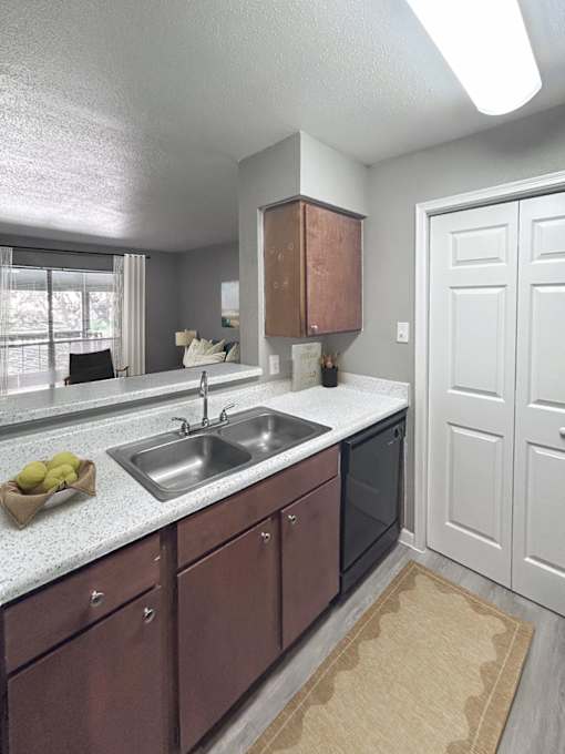A kitchen with brown cabinets and a white sink.