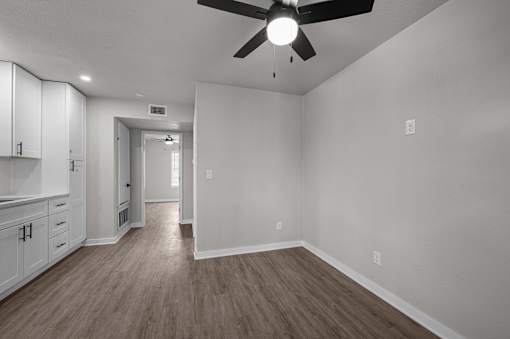 an empty living room with white walls and a ceiling fan  at Sunset Heights, San Antonio