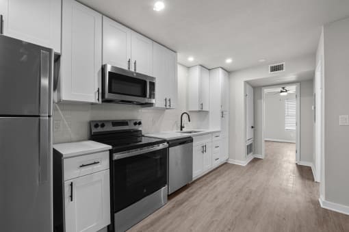 Photo of newly renovated kitchen with stainless steel appliances and white cabinetry at Sunset Heights, San Antonio, 78209