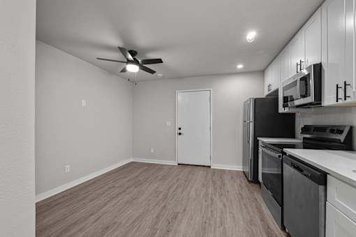 the living room of a home with a kitchen and a ceiling fan at Sunset Heights, San Antonio, TX, 78209
