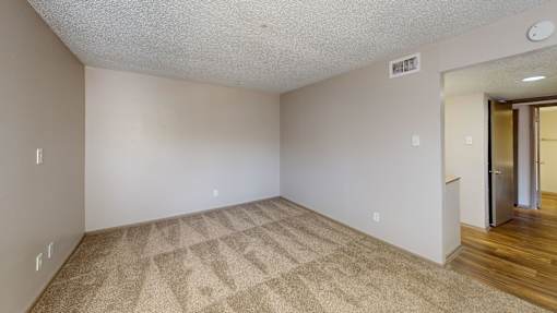 A room with a carpeted floor and a door on the right.