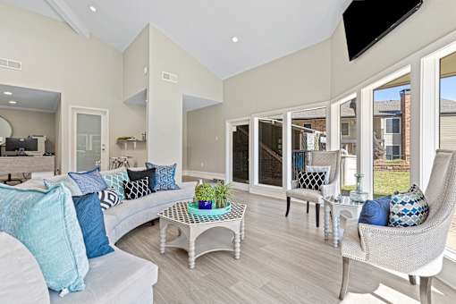 A living room with a white couch and a glass table.