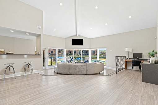 A spacious room with a television, a desk, and a large window overlooking a pool.
