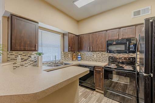 A kitchen with a black oven and microwave.