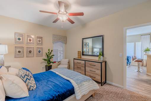 A bedroom with a bed, dresser, and mirror.