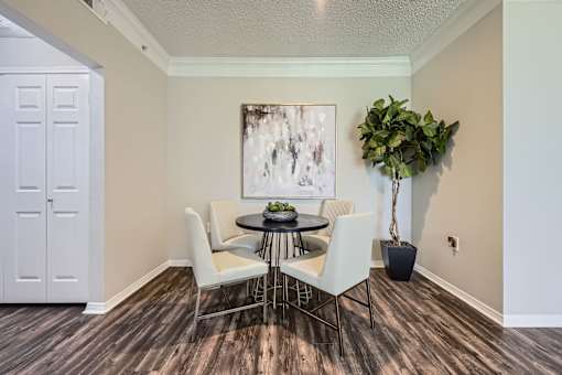 A dining room with a table and chairs.