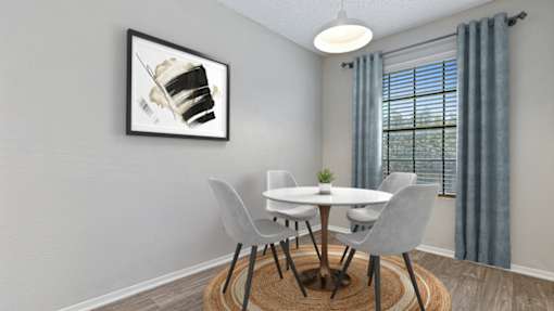 A dining room with a white table and grey chairs.