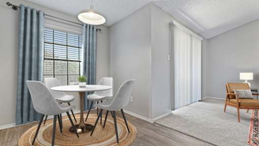 A dining room with a round table and chairs.