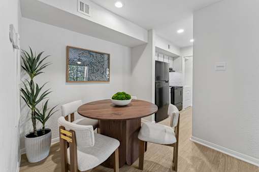 Dining area with round wood table and chairs at Knoll Crest Apartments, San Antonio, Texas