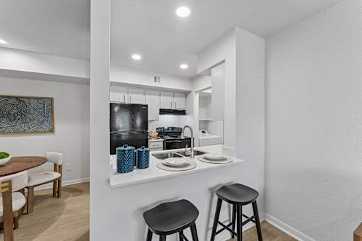 Modern kitchen with white cabinets and breakfast bar at Knoll Crest Apartments, Texas, 78240