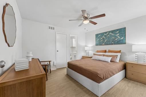 Bedroom with ceiling fan and coastal artwork at Knoll Crest Apartments, San Antonio, TX 78240