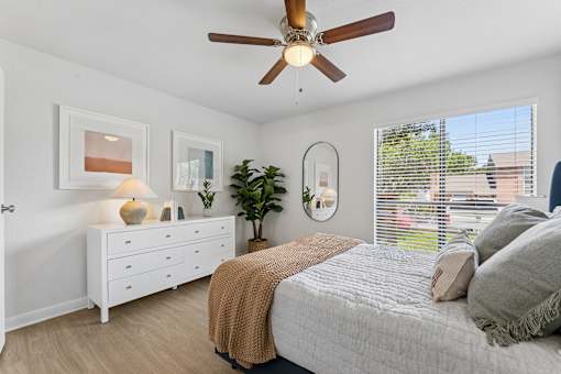 Bedroom with ceiling fan and large window at Knoll Crest Apartments, San Antonio, Texas