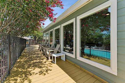 Covered outdoor deck with seating and pool view at Knoll Crest Apartments, Texas