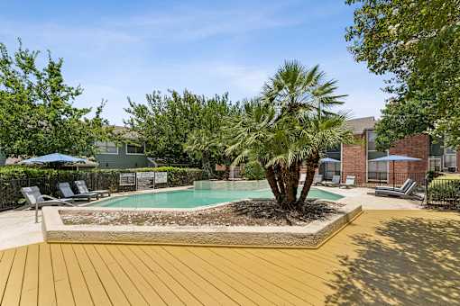 Pool deck with palm trees and lounge seating at Knoll Crest Apartments, San Antonio, 78240